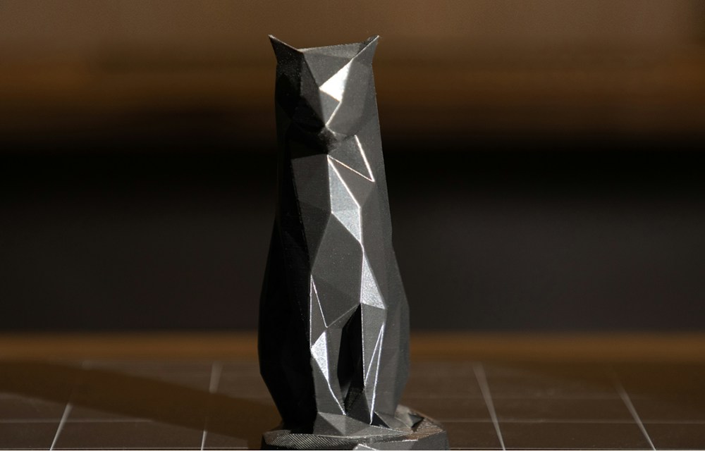 A black geometric cat figurine made with a 3D printer